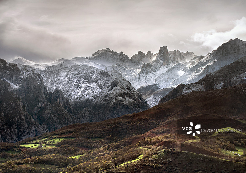 西班牙卡夫拉莱斯阿西埃戈，多云天空下白雪皑皑的山脉和山谷的壮丽景色图片素材