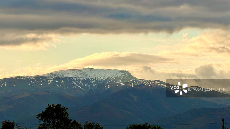 日落时分，白雪皑皑的山脉在戏剧般的天空中构成了一幅壮丽的风景，展示了自然之美和不断变化的光线，保加利亚卡赞勒克。图片素材