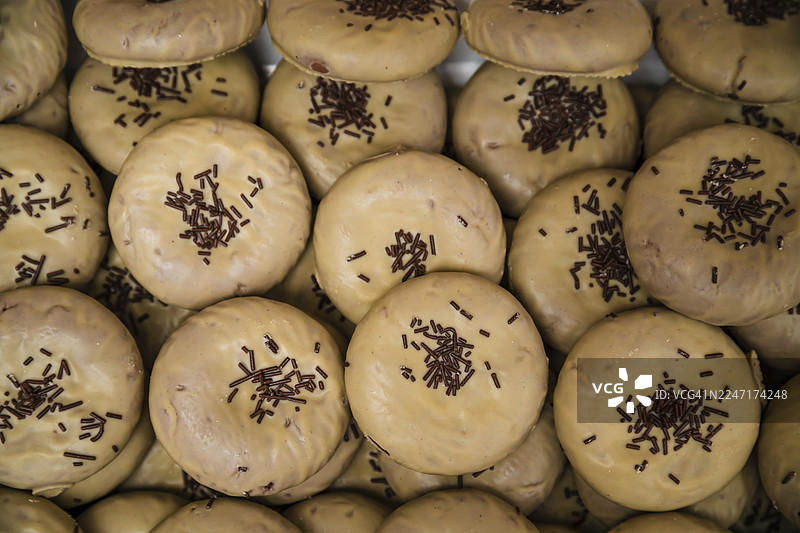 市场摊位上出售的撒有糖珠的甜甜圈的全景照片图片素材