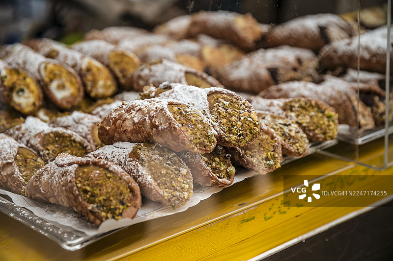 橱窗里美味的奶油空心酥卷，内填开心果酱，撒上糖粉图片素材