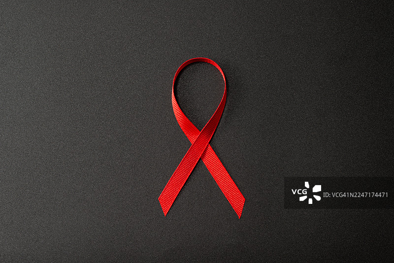 深色背景上的红色意识丝带，象征着对各种事业的支持图片素材