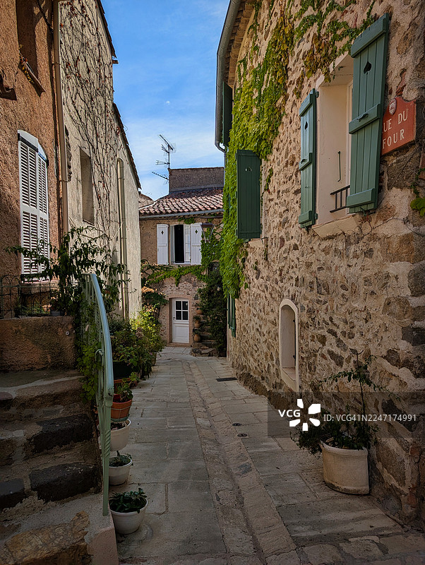 法国格里莫，一座历史悠久的欧洲村庄里迷人的狭窄小巷，两旁是石砌建筑和茂密的常春藤。图片素材