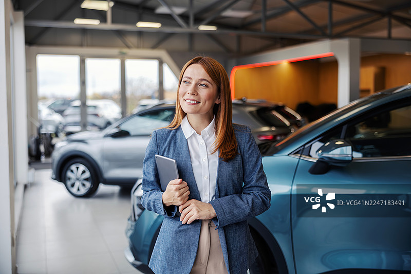 汽车销售人员在汽车经销商处使用平板电脑图片素材
