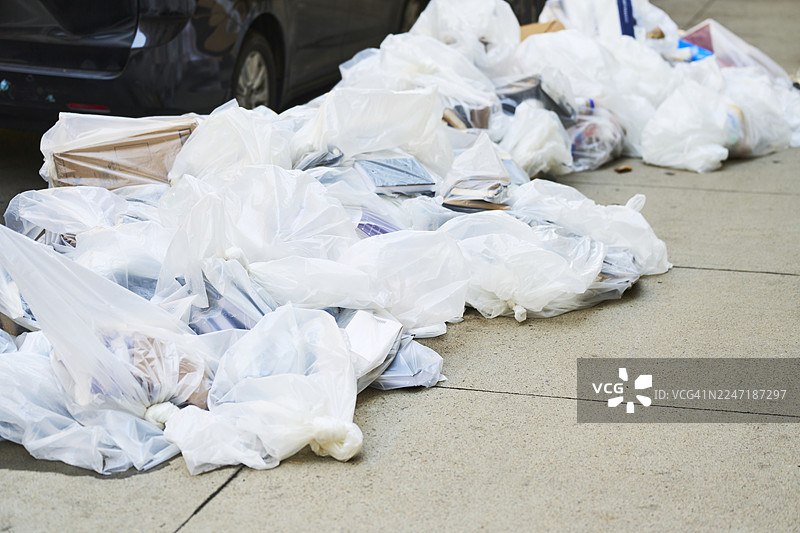 垃圾袋在城市街道人行道上造成污染图片素材