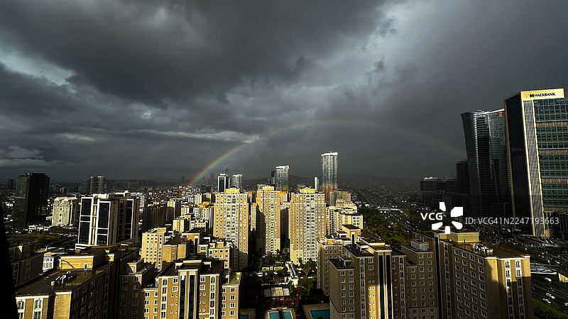 一场风暴过后，一道充满活力的彩虹划过现代化的城市天际线，象征着希望。土耳其。图片素材