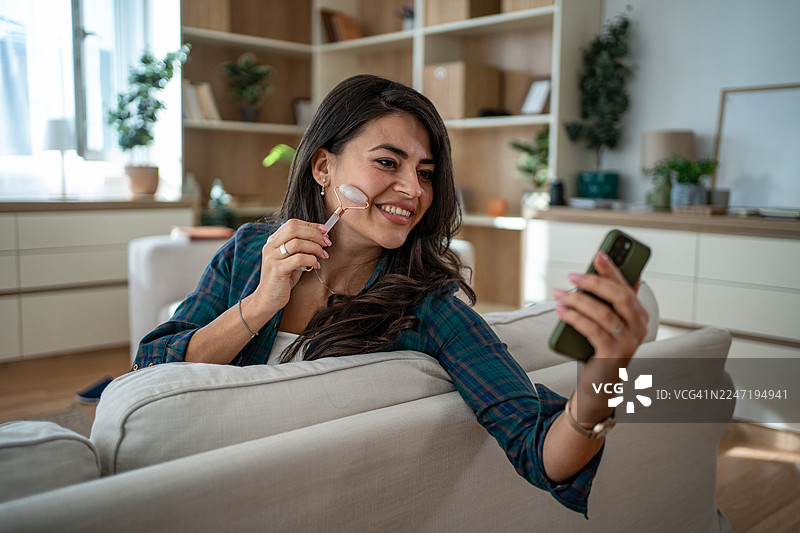年轻女子享受自我护理，使用玉石滚轮图片素材