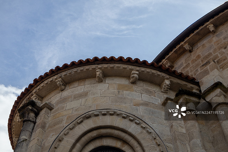 低角度拍摄法国康塔尔地区一座红瓦石制历史建筑，背景为蓝天。图片素材