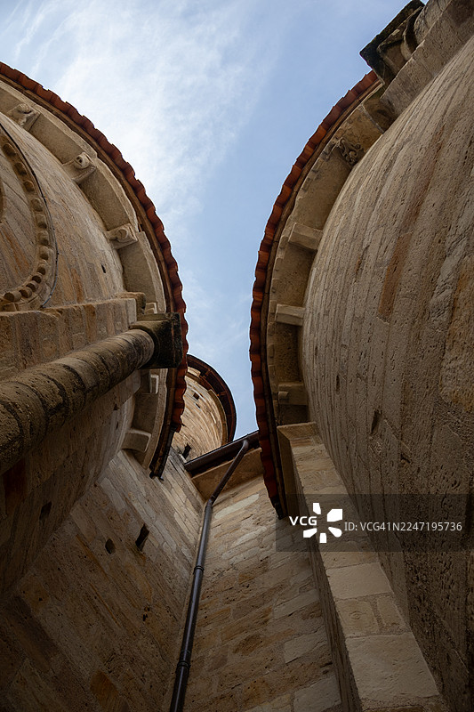 法国康塔尔地区，阴天背景下的古老石头建筑低角度仰视图片素材