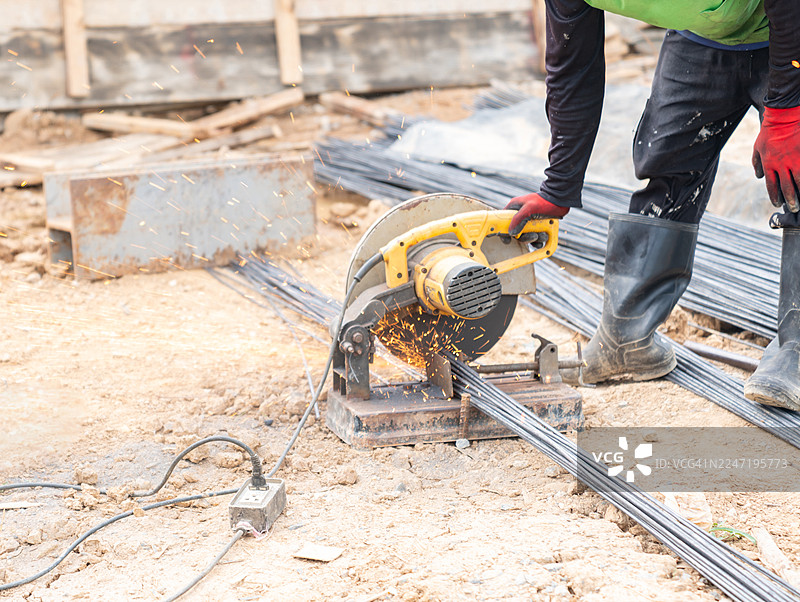 建筑工人在建筑工地上用砂轮锯切割钢筋，火花四溅图片素材
