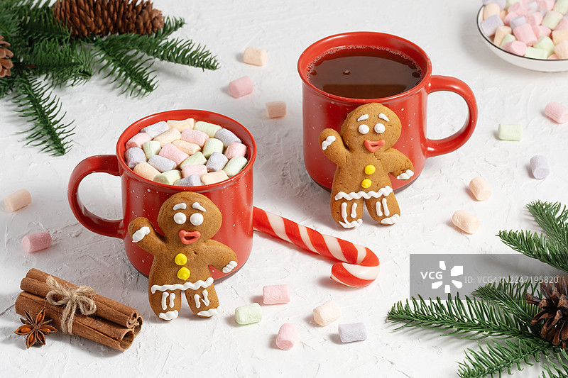 白色桌子上圣诞装饰品的高角度视图，包括饼干、拐杖糖、热巧克力和棉花糖图片素材