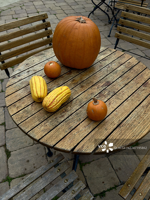 高角度俯视，展示了乡村木桌上各种南瓜和葫芦，已准备好用于秋季装饰。图片素材