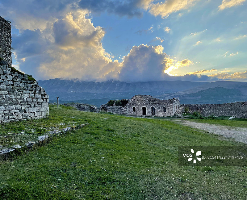 阿尔巴尼亚，山脉与落日天空下的草坡古石遗址图片素材