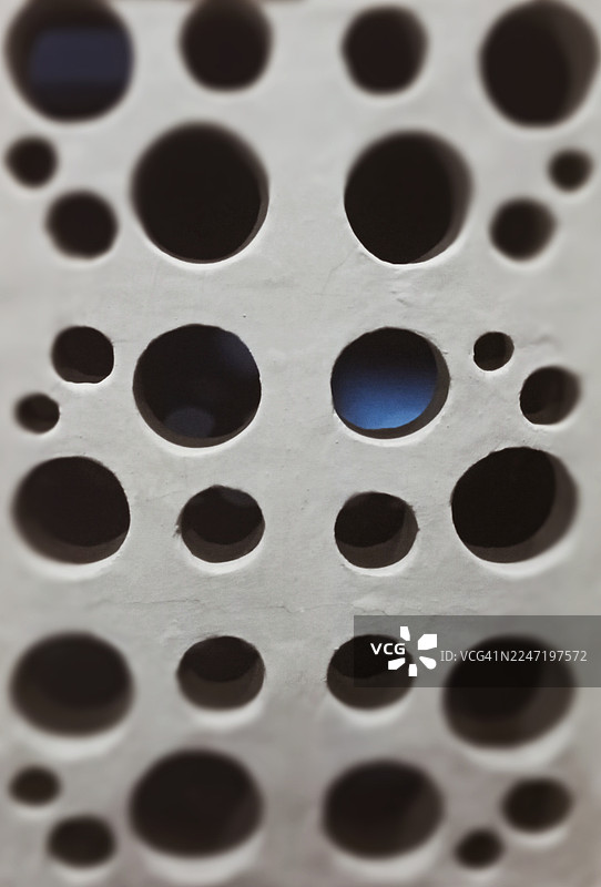 印尼 Sungai Kunjang 区金属格栅的完整画面，格栅孔洞大小不一，并带有蓝色反光图片素材