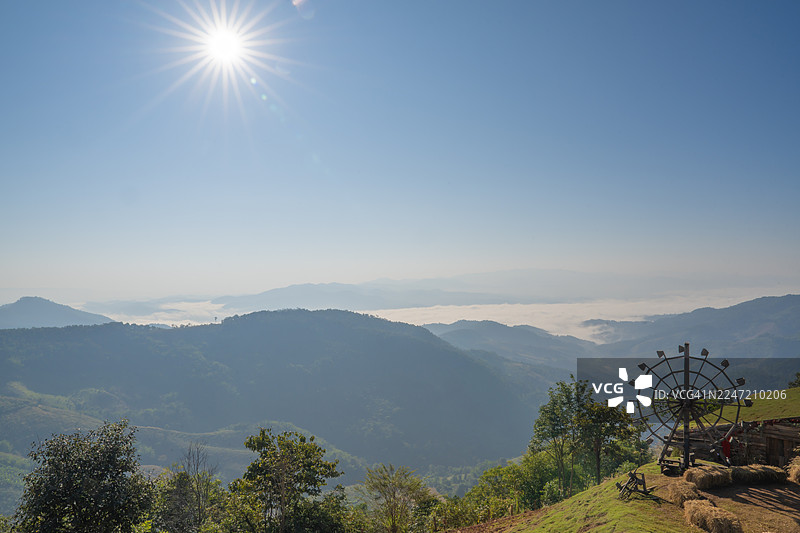 原生态，木制水轮机。山丘上带有干草立方体的木制水车，背景为蓝天。图片素材
