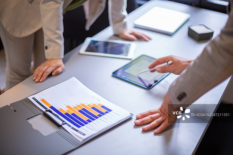 商业专业人士在文件和数字平板电脑上分析图表图片素材