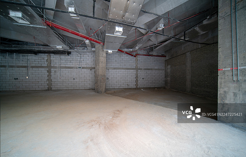 暴露着管道和横梁的地下混凝土房间图片素材