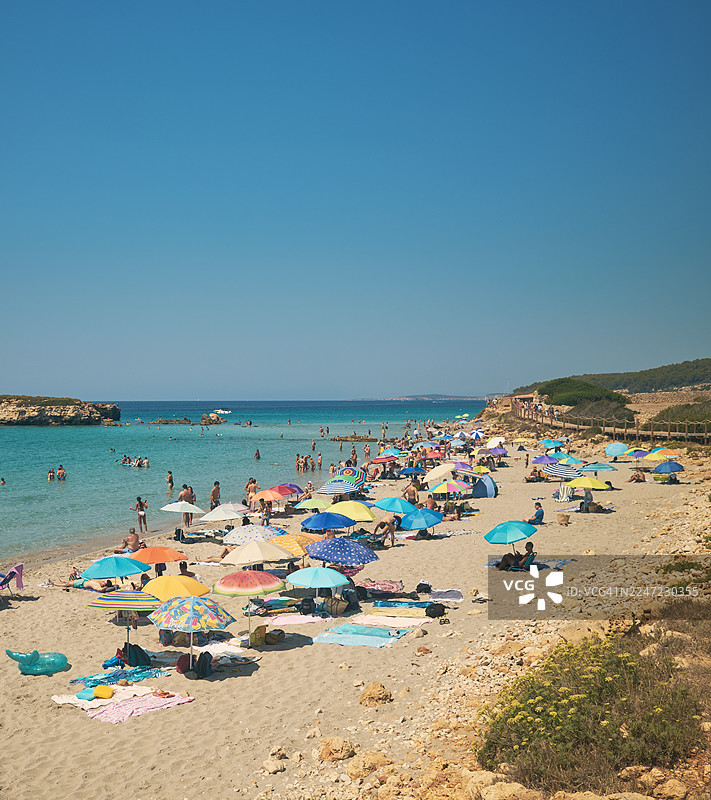 人们在梅诺卡岛的圣托马斯海滩享受阳光和游泳图片素材