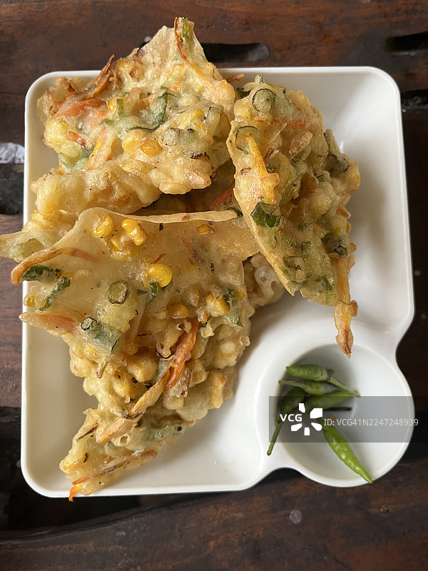 白盘上的印尼玉米煎饼（Bakwan Jagung）配青辣椒图片素材