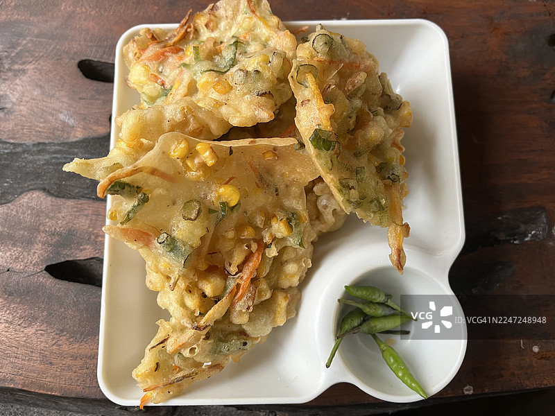白盘上的印尼玉米煎饼（Bakwan Jagung）配青辣椒图片素材