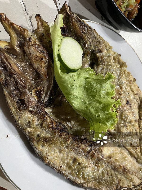 特写：白盘子里的烤鱼图片素材