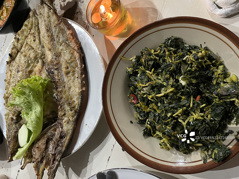 烤鱼配炒木瓜叶图片素材