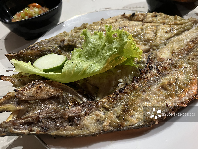 白色盘子上的烤鱼特写图片素材