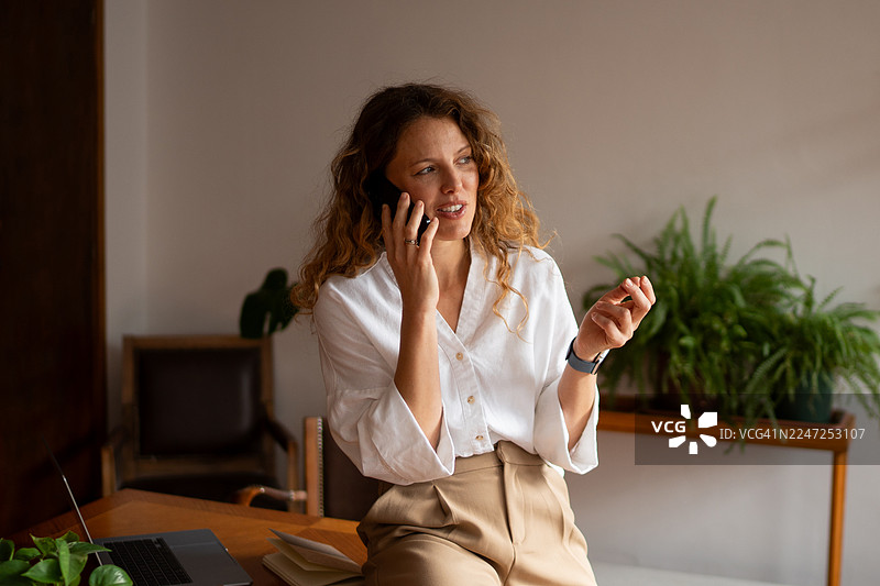 女商人在现代办公室里打电话工作图片素材