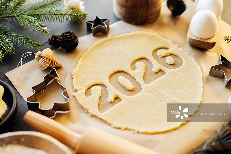 姜饼生面团，上面有切好的数字“2026”，以及用于制作圣诞节日饼干的烘焙原料。新年快乐，2026。俯视，平面图。圣诞烘焙概念。图片素材