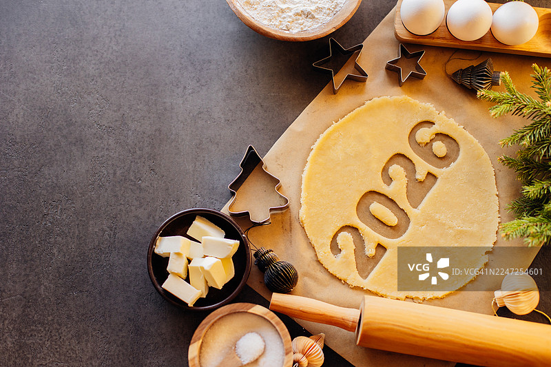 带有数字2026切块的面团，周围环绕着鸡蛋、面粉、糖和节日装饰等烘焙原料，营造出节日庆典的温馨氛围图片素材