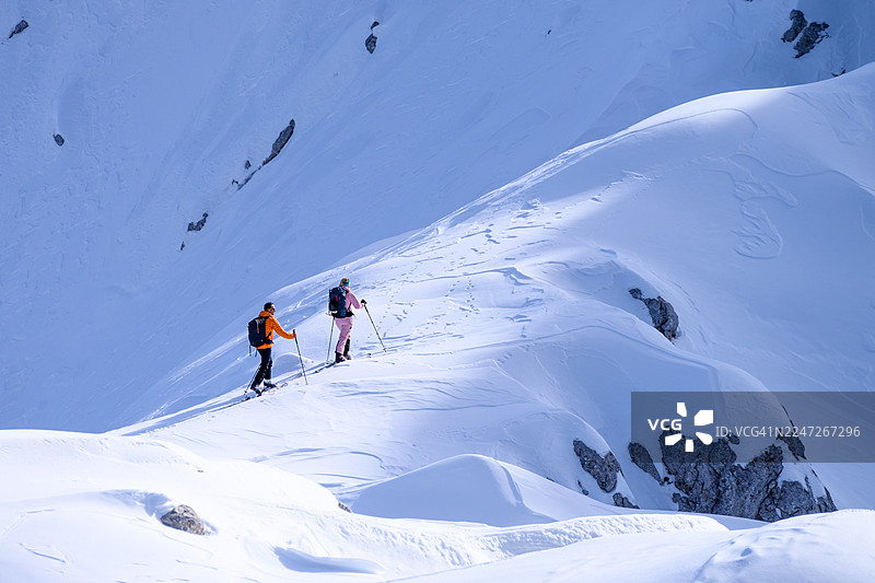 中年白人夫妇在原始雪坡上享受滑雪徒步的探险图片素材