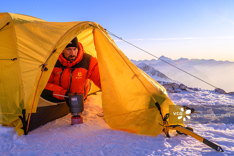 冬季在高山大本营准备餐食的成熟高加索登山者图片素材