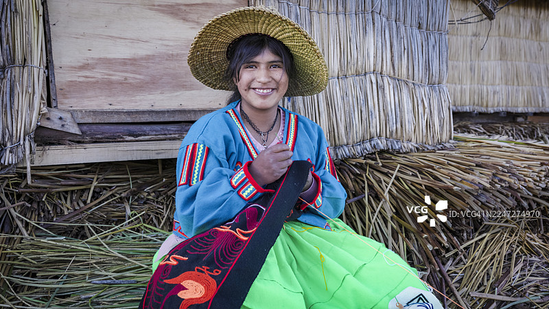 秘鲁乌鲁斯浮岛上的年轻秘鲁妇女售卖纪念品，的的喀喀湖，秘鲁图片素材
