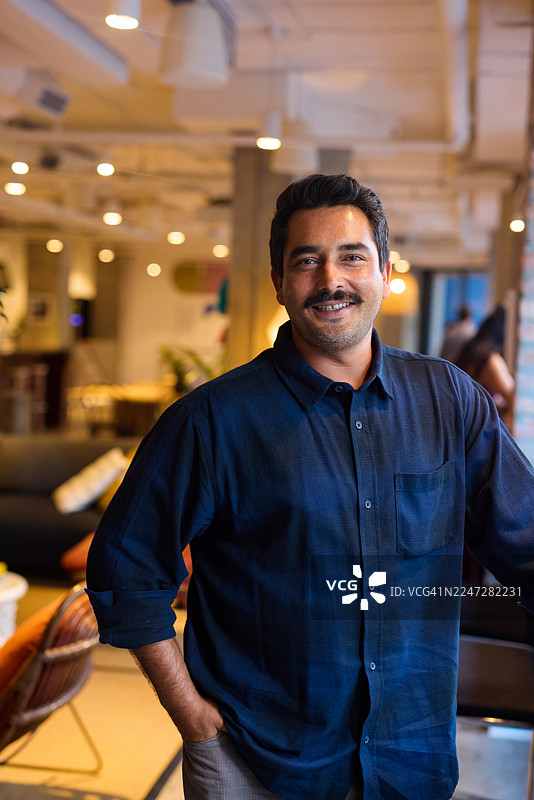 微笑的男士在现代创业公司办公室工作图片素材