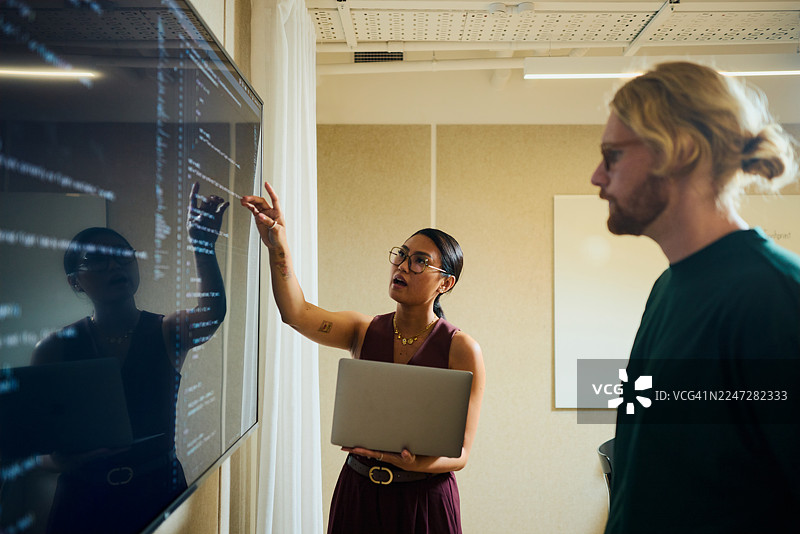 商业专业人士在数字屏幕上协作开发人工智能代码图片素材