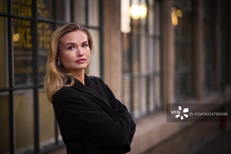 户外拍摄的年轻女性半身像，身着暖和的衣物图片素材