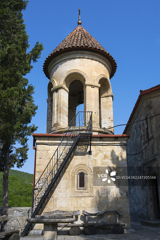 圆形的教堂塔楼，带有石砌台阶和红屋顶，坐落于宁静的乡村环境中，位于格鲁吉亚伊梅列季地区库塔伊西附近的莫特萨梅塔修道院。图片素材