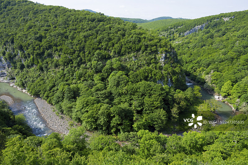 格鲁吉亚伊梅列季大区库塔伊西市莫察梅塔修道院俯瞰扎尔齐特拉河，河畔绿意盎然的森林被群山环绕图片素材