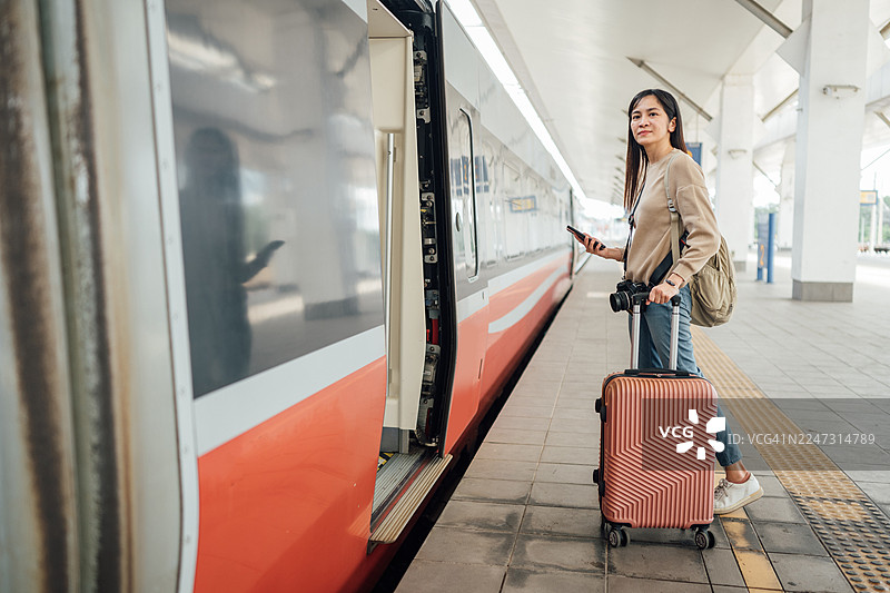 出发前一刻：一位女士正在观察驶来的火车图片素材