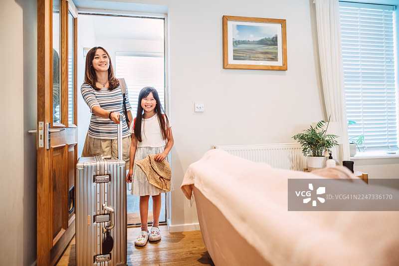 妈妈和女儿抵达度假屋，准备家庭度假图片素材