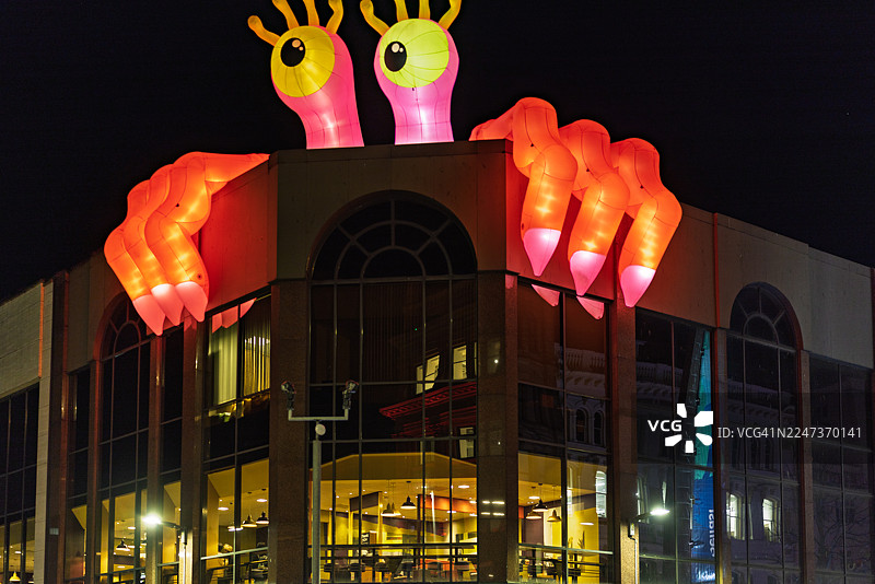 巨大的充气生物展示在玻璃幕墙之上图片素材