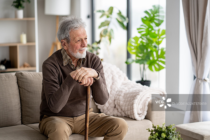 一位年长的男士沉思，沐浴在自然光中。图片素材
