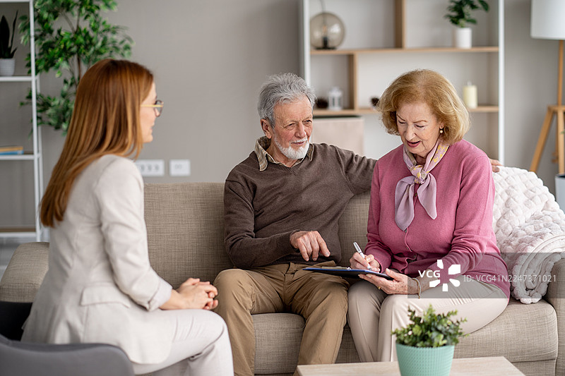 年迈的夫妇与他们的看护者之间的温馨互动图片素材