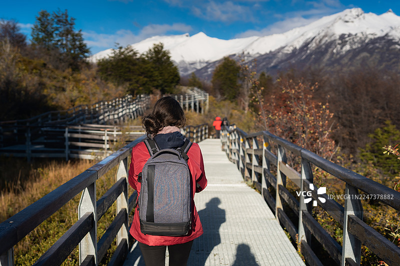 一位女士在巴塔哥尼亚的佩里托莫雷诺冰川上的人行木栈道徒步图片素材