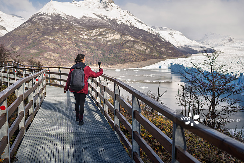 一名女子在阿根廷巴塔哥尼亚的佩里托莫雷诺冰川前进行视频博客录制图片素材