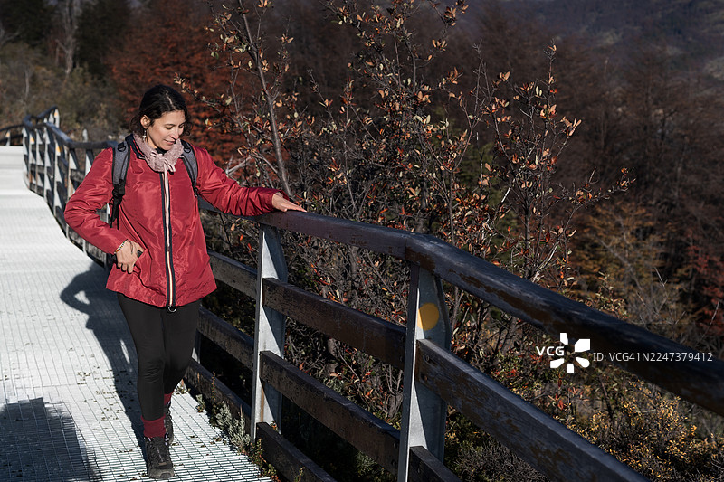 一名女子在巴塔哥尼亚佩里托莫雷诺冰川的桥上徒步探索图片素材