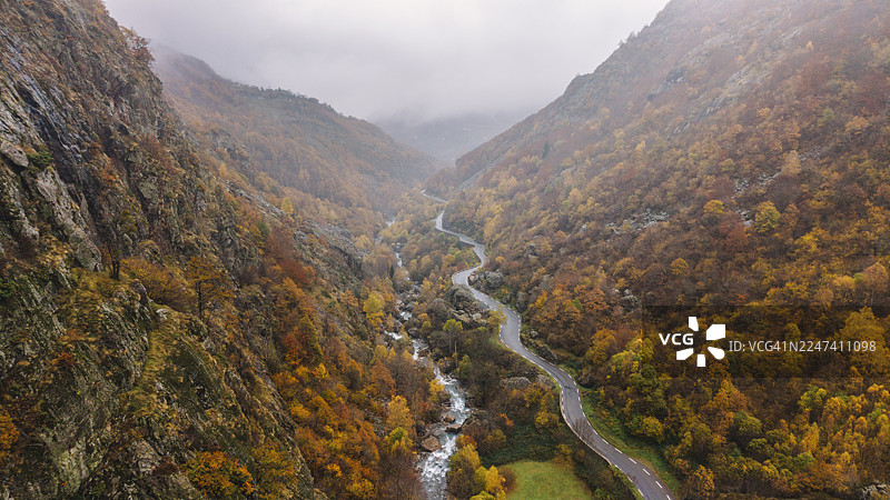 秋日雨天，法国比利牛斯山脉深谷中，道路与河流交织的航拍/无人机视角图片素材