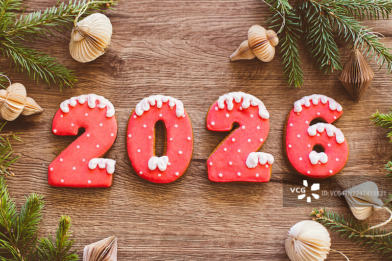 木桌上用红色糖霜装饰的2026节日饼干图片素材