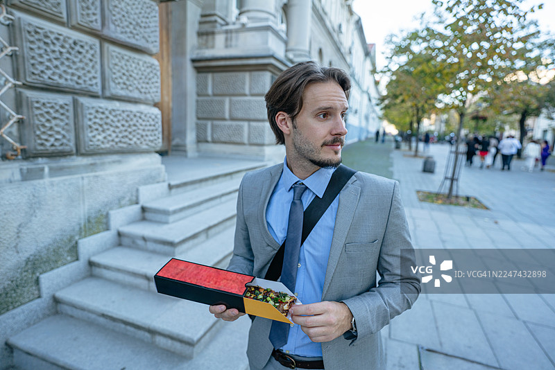 商务人士在午休时间快速吃点零食图片素材