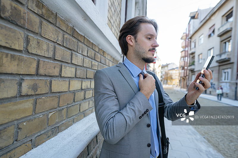 英俊的年轻商人正在整理领带图片素材