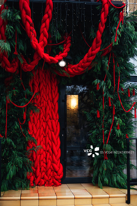 这座玻璃建筑的店面和入口处装饰着圣诞和新年装饰，店内也布置了圣诞树，展现出节日房屋的装饰氛围。图片素材